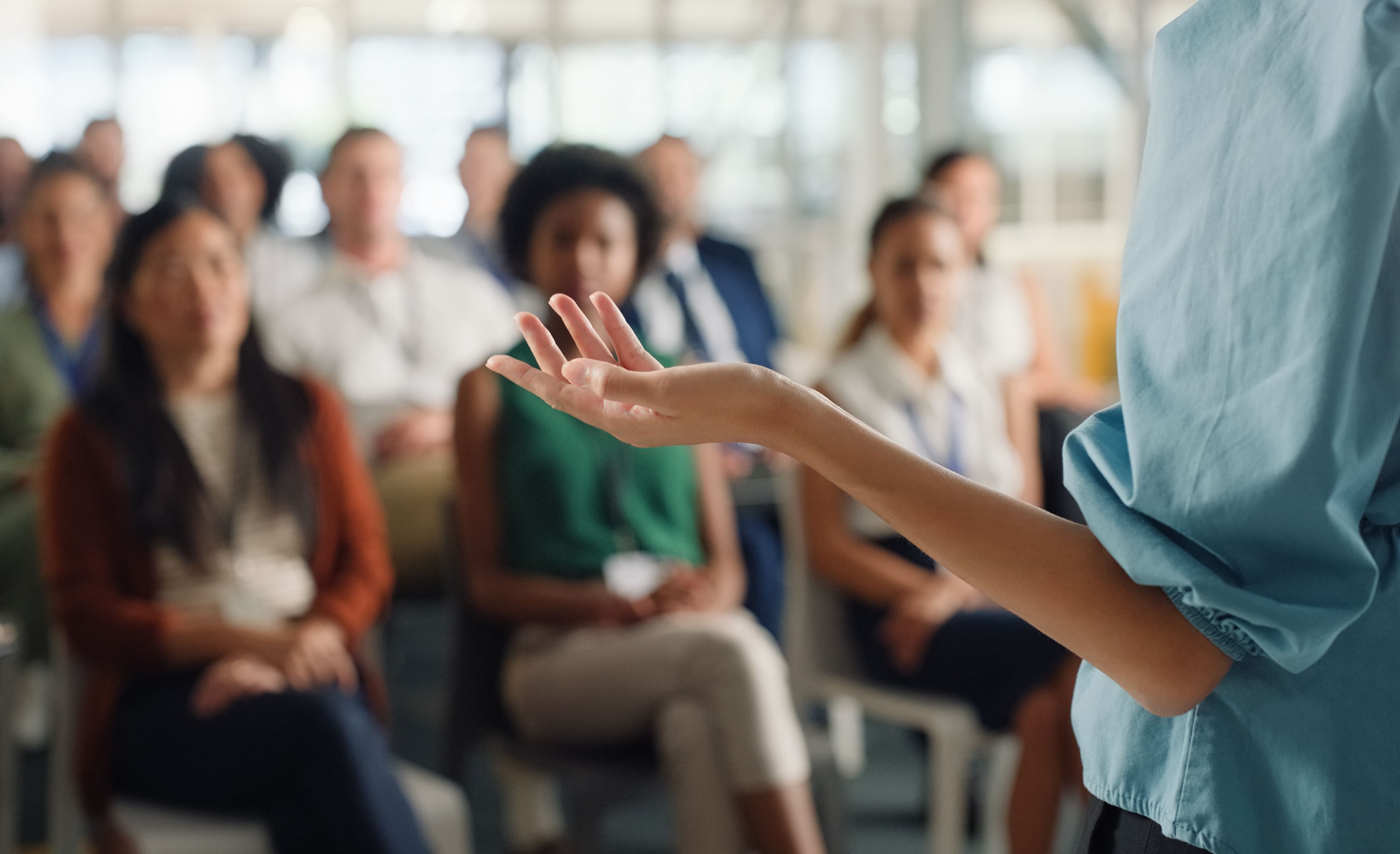 Intervenant parlant devant un groupe d'adultes lors d'une intervention en entreprise ou d'une formation professionnelle.